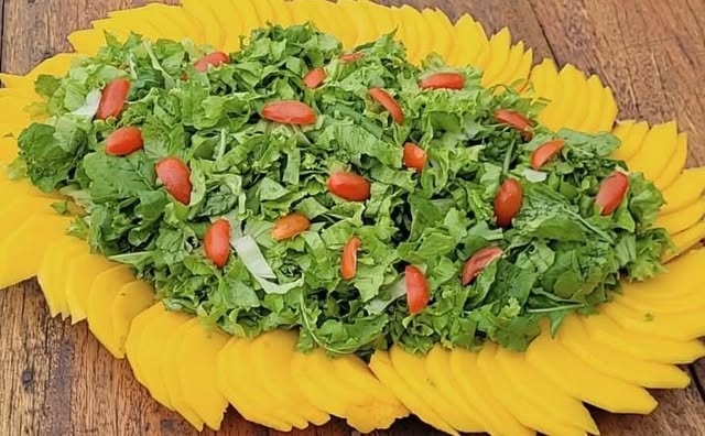 Travessa de salada de folhas com tomate e manga fatiada
